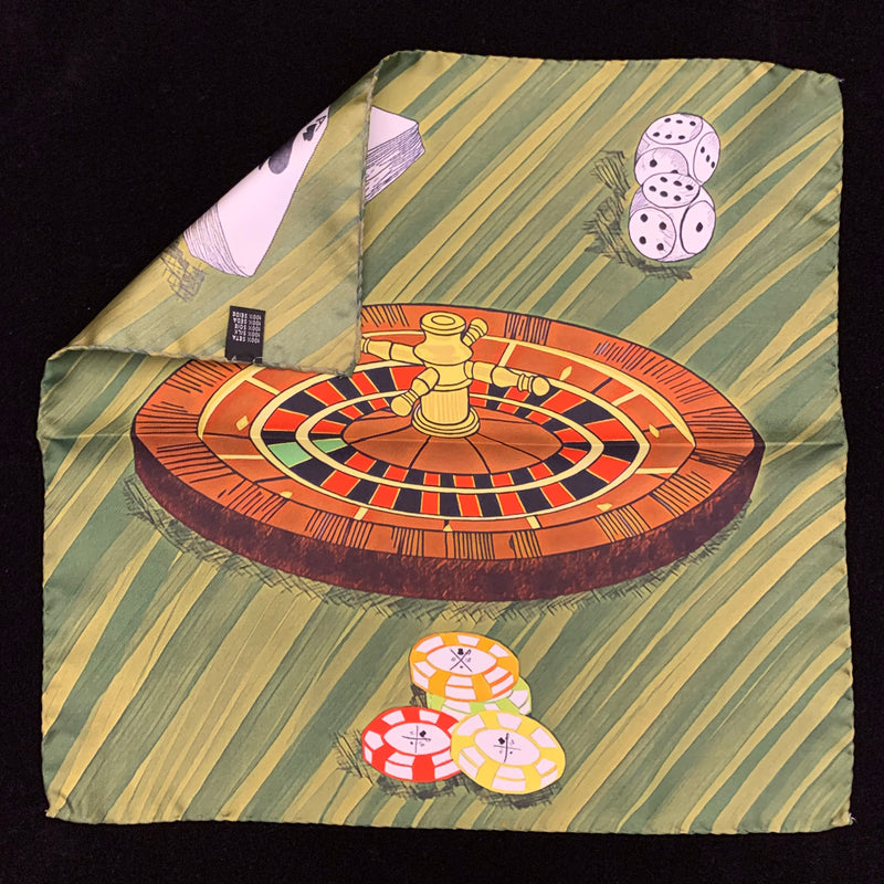 Pocket square with roulette wheel, deck of cards, dice and poker chips on a dark green background