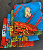 Folded pocket squares with dice and roulette table on top of folded pocket squares with Fabulous Las Vegas sign